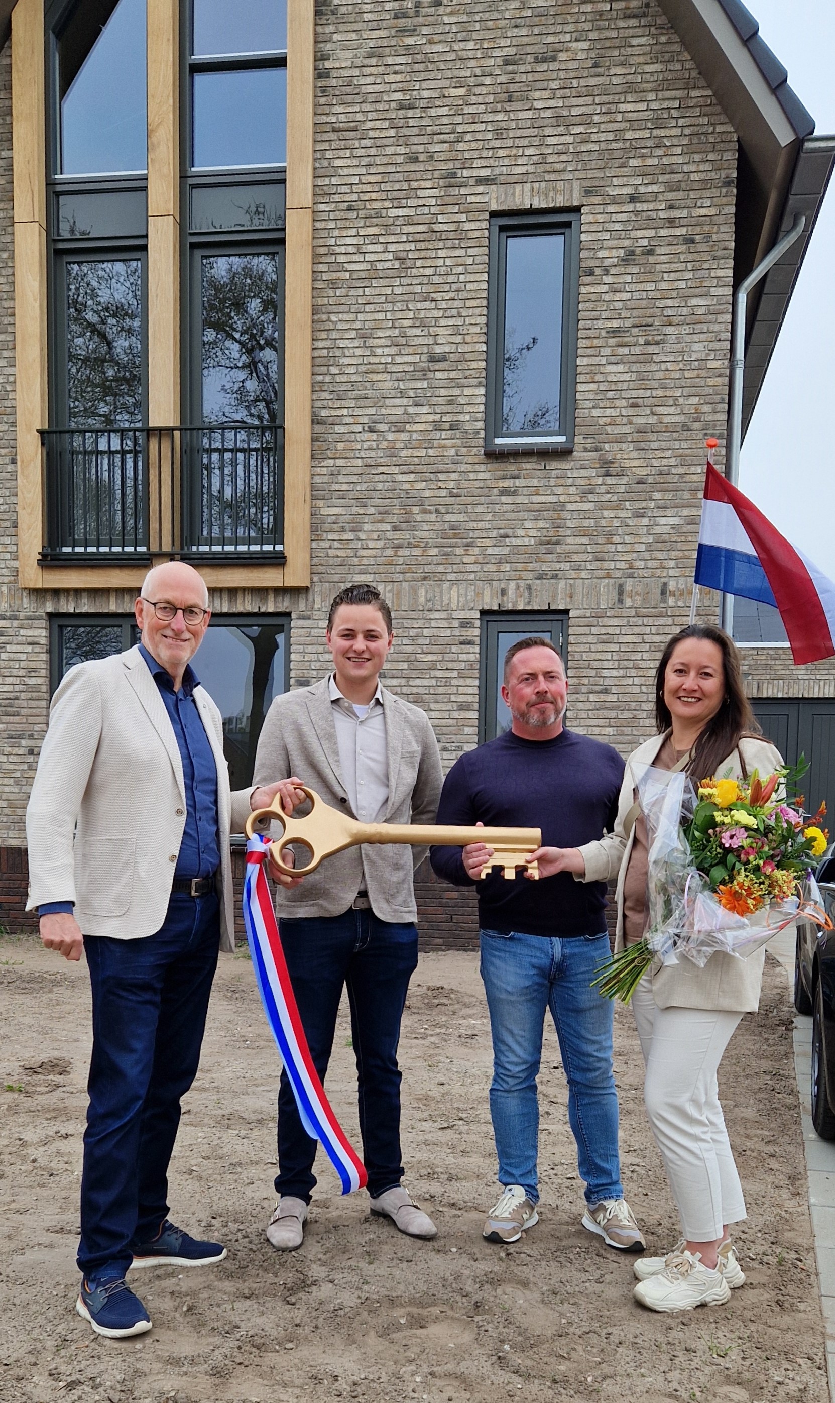 Wethouder Eskes overhandigt de sleutel aan de nieuwe bewoners.